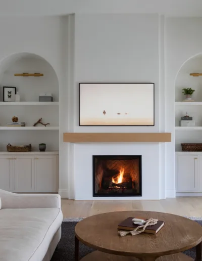 A living room with white walls and a fireplace.
