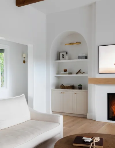 A white living room with a fireplace and tv.