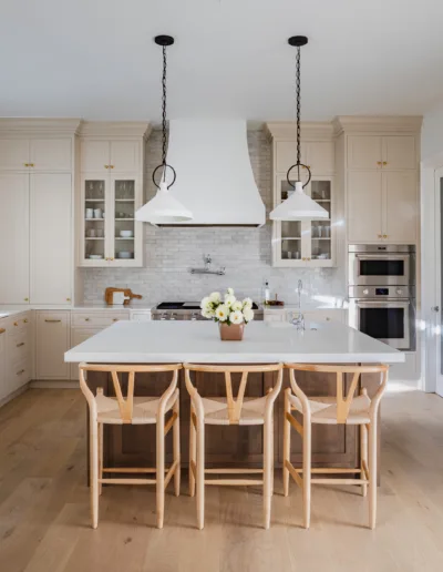 A white kitchen with wooden floors and a center island.