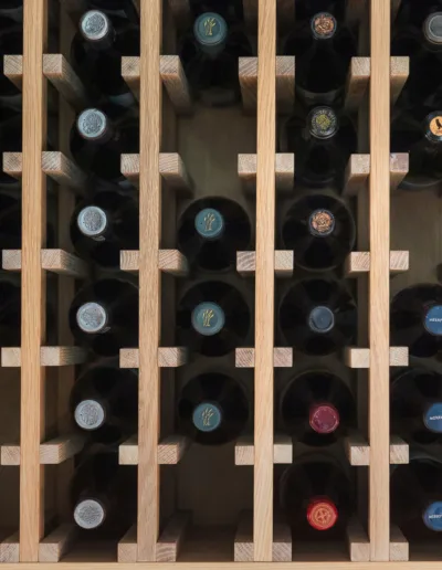 A wooden wine rack with many bottles of wine.