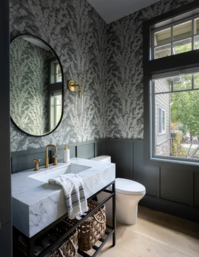 A bathroom with a sink, mirror and wallpaper.
