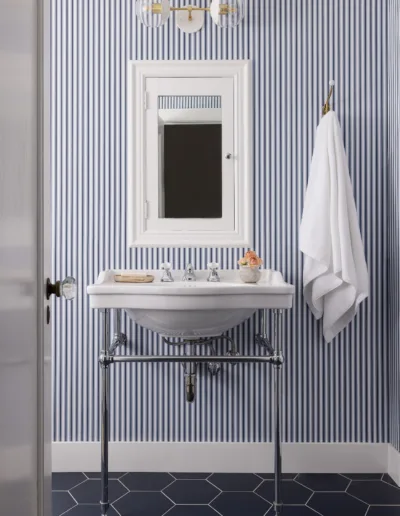 A bathroom with blue and white striped wallpaper.