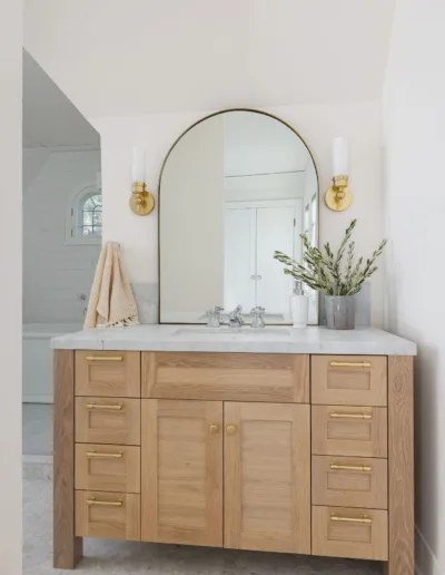 A bathroom with a wooden vanity and a mirror.