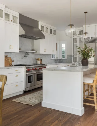A white kitchen with wood floors and a center island.