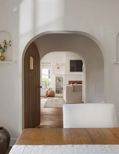 A white dining room with an arched doorway.