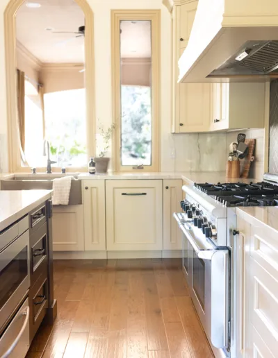 A white kitchen with wood floors and an oven.