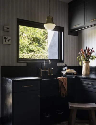 A kitchen with black cabinets and a window.