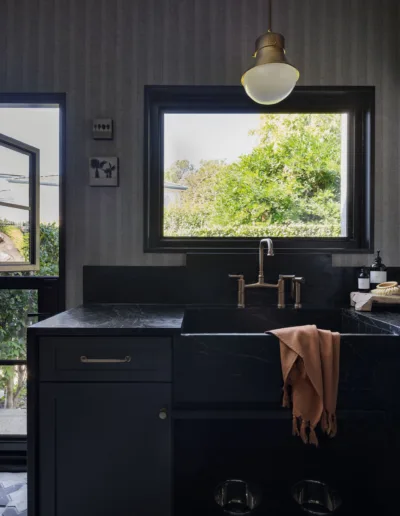 A black sink in a kitchen with a window.